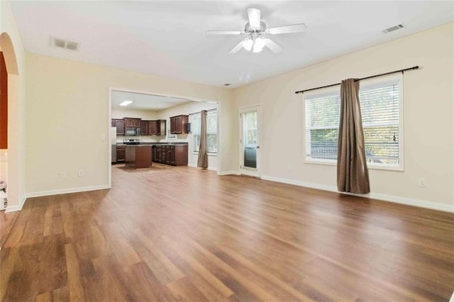 unfurnished living room featuring hardwood / wood-style flooring and ceiling fan