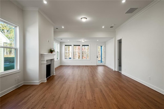 unfurnished living room with ornamental molding, a healthy amount of sunlight, and hardwood / wood-style floors