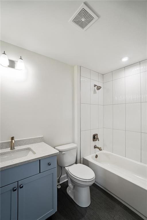 full bathroom featuring tiled shower / bath combo, vanity, and toilet