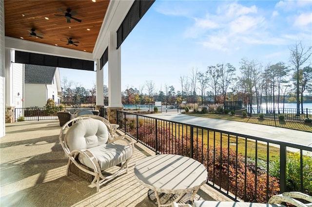 balcony featuring a water view and ceiling fan