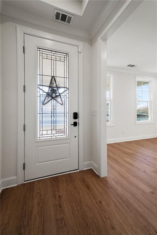 entryway with crown molding, a healthy amount of sunlight, and hardwood / wood-style floors