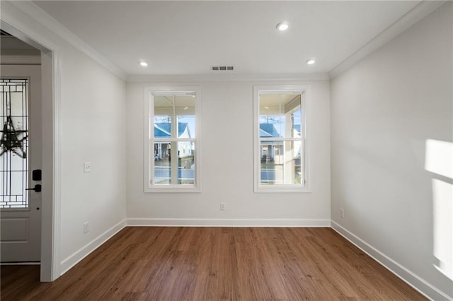 interior space featuring a wealth of natural light, ornamental molding, and wood-type flooring