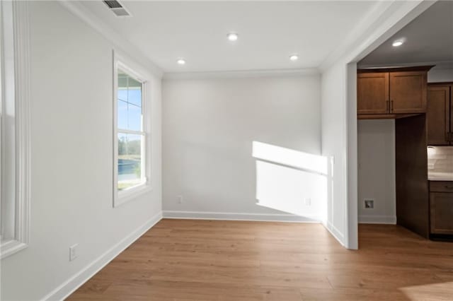 unfurnished dining area featuring light wood-type flooring and ornamental molding