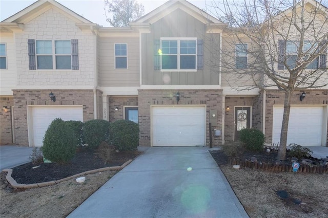 multi unit property featuring a garage, board and batten siding, concrete driveway, and brick siding