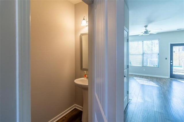 bathroom featuring a ceiling fan, baseboards, and wood finished floors