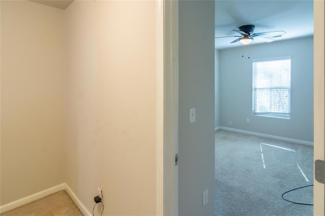 interior space featuring light carpet, ceiling fan, and baseboards