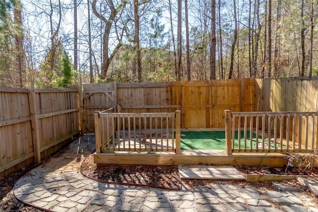 wooden terrace with a fenced backyard