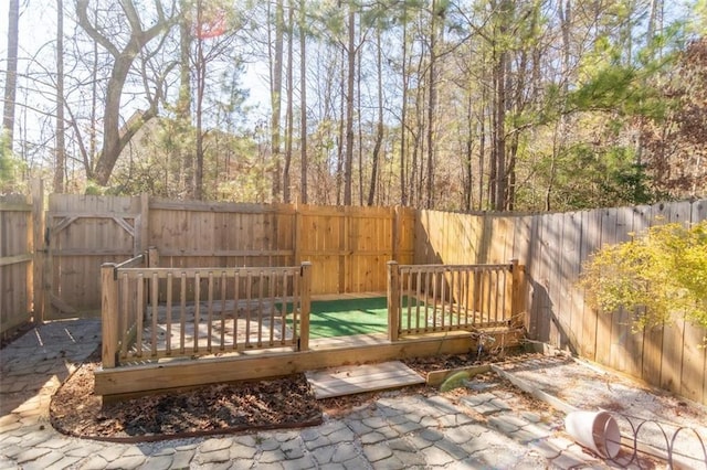 wooden deck with a fenced backyard and a patio