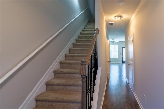 stairs with baseboards, ceiling fan, visible vents, and wood finished floors