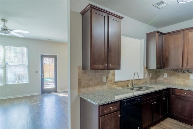 kitchen featuring light stone counters, a sink, visible vents, backsplash, and dishwasher