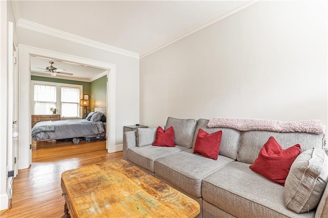 living room featuring ornamental molding, light wood finished floors, and baseboards