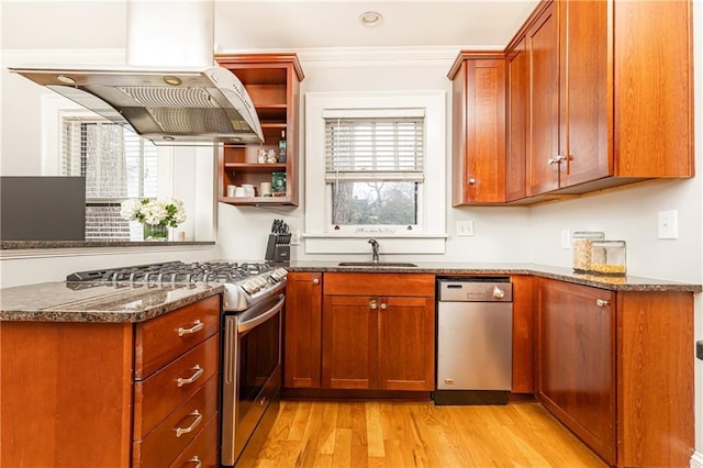 kitchen featuring appliances with stainless steel finishes, a sink, plenty of natural light, a peninsula, and ornamental molding