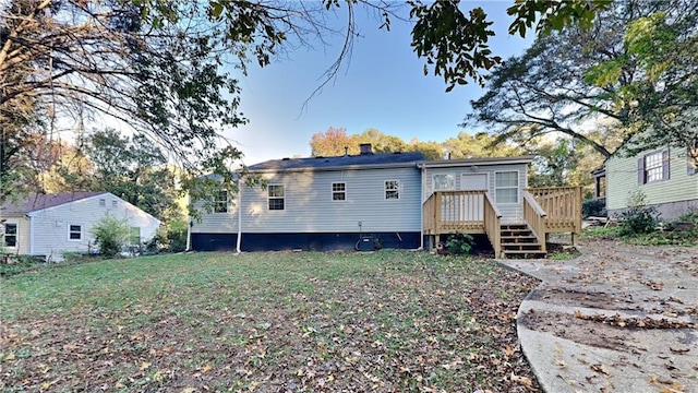 rear view of house featuring a wooden deck and a yard