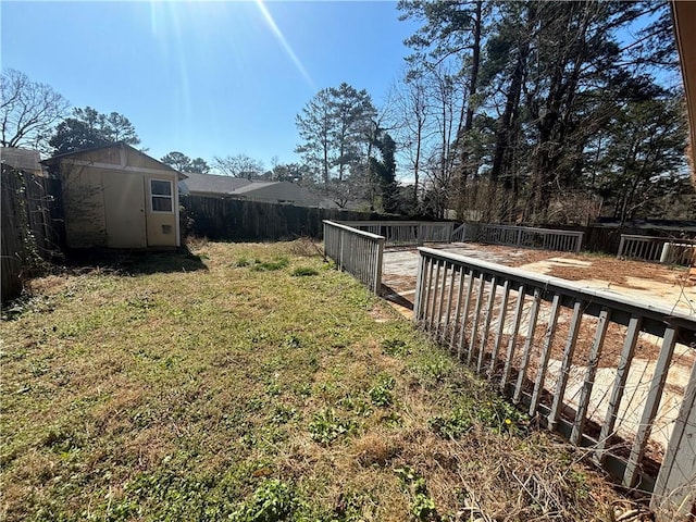 view of yard featuring a fenced backyard, an outdoor structure, and a storage unit