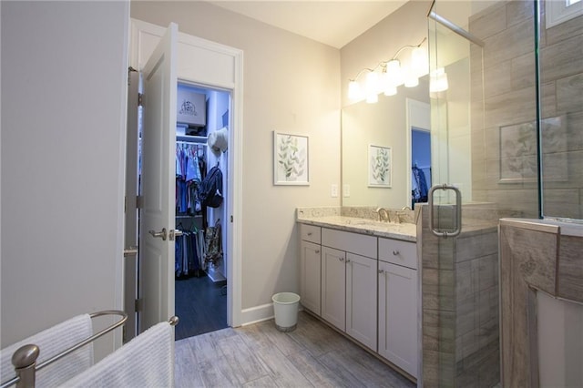 3719 Cresswind Pkwy SW, Gainesville, GA 30504 - bathroom with vanity, a spacious closet, wood finished floors, and a stall shower