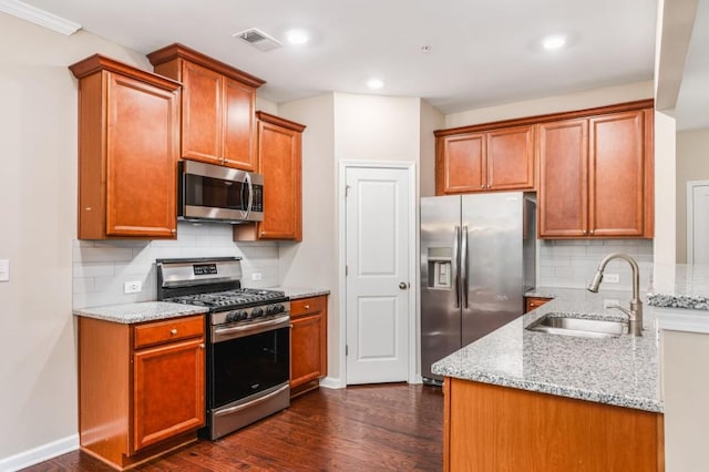 kitchen featuring light stone countertops, sink, dark hardwood / wood-style floors, backsplash, and appliances with stainless steel finishes