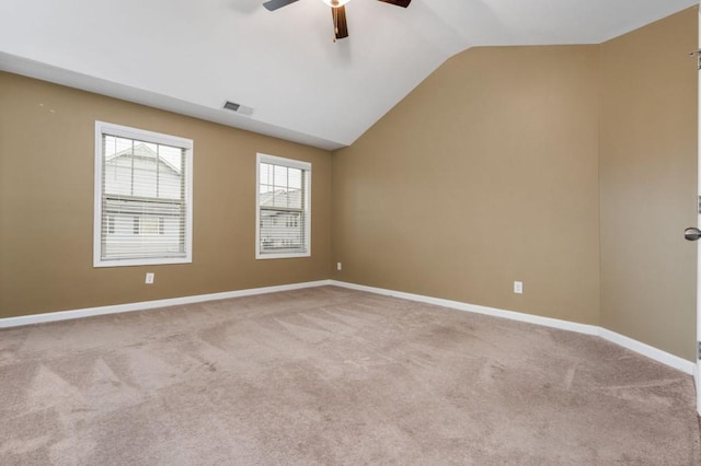 carpeted spare room featuring ceiling fan and vaulted ceiling