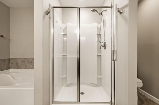 bathroom featuring toilet, tile patterned floors, and plus walk in shower