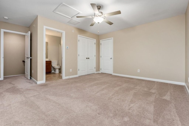 unfurnished bedroom with ceiling fan, light colored carpet, and ensuite bath