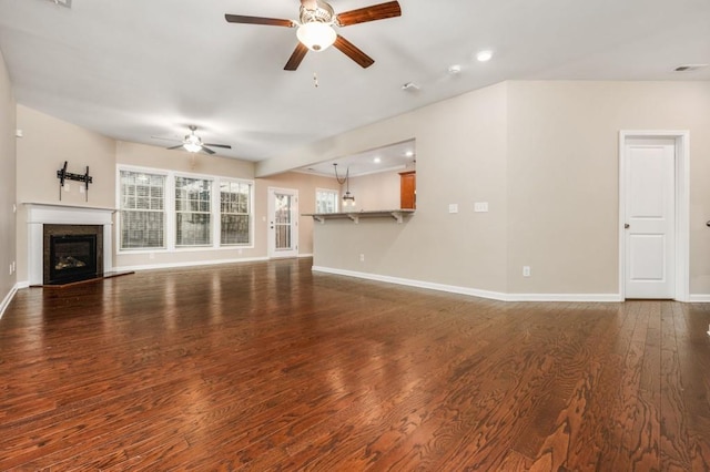 unfurnished living room featuring ceiling fan and dark hardwood / wood-style flooring