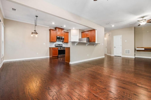 kitchen featuring a kitchen breakfast bar, ceiling fan, stainless steel appliances, and decorative light fixtures