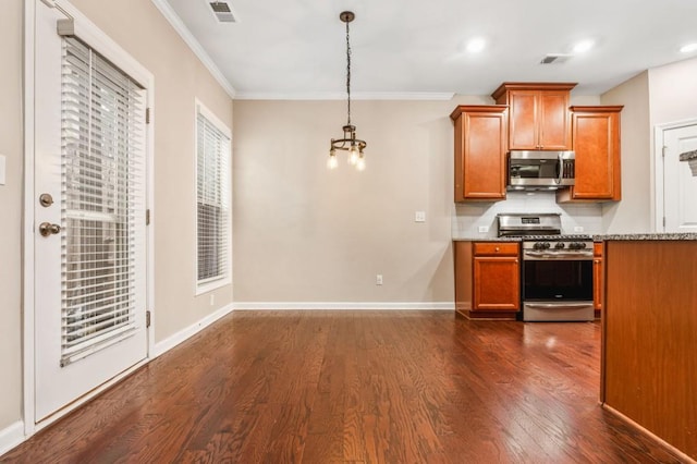 kitchen with dark wood-type flooring, crown molding, hanging light fixtures, decorative backsplash, and appliances with stainless steel finishes