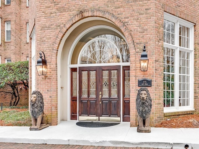 view of exterior entry featuring brick siding and french doors