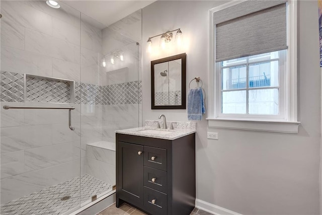 full bathroom with vanity, baseboards, and a stall shower