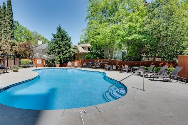community pool with fence and a patio