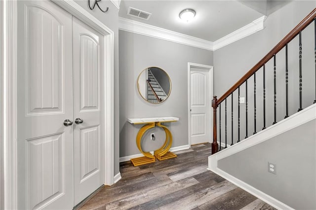 entryway featuring crown molding, visible vents, wood finished floors, baseboards, and stairs