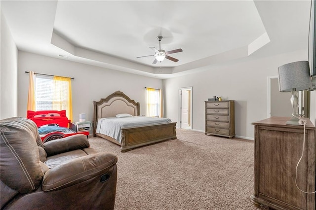 bedroom featuring a tray ceiling, carpet flooring, ceiling fan, and baseboards