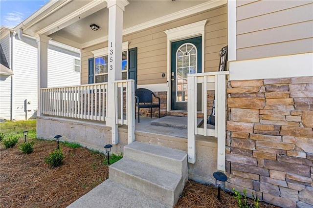 view of exterior entry featuring covered porch