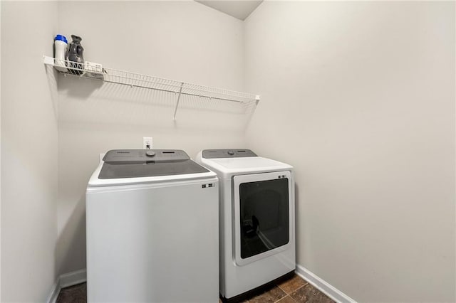 washroom featuring laundry area, washer and clothes dryer, and baseboards