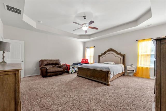 bedroom featuring carpet, visible vents, a raised ceiling, and baseboards