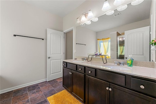 full bathroom featuring a stall shower, a sink, visible vents, and baseboards