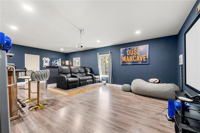 home theater room featuring baseboards, wood finished floors, and recessed lighting