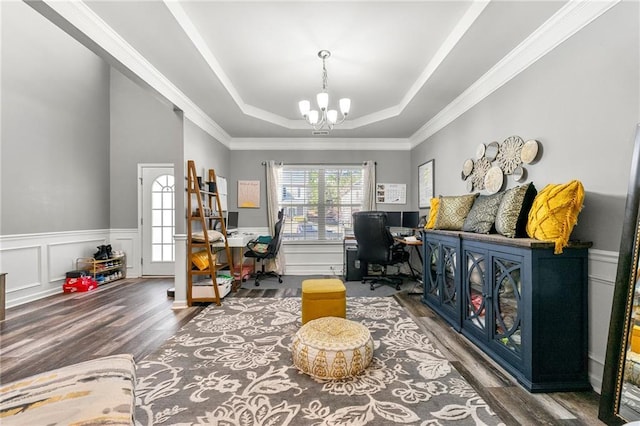 game room featuring a wainscoted wall, a raised ceiling, a decorative wall, an inviting chandelier, and wood finished floors