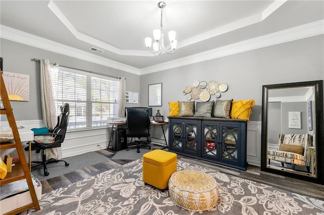 office space featuring visible vents, wainscoting, ornamental molding, a tray ceiling, and a chandelier