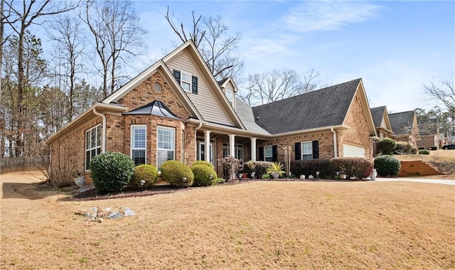 view of front of house featuring a front lawn, a garage, fence, and brick siding