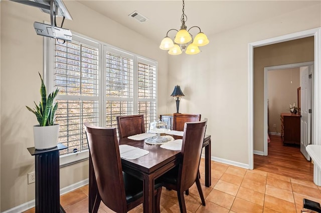 dining space featuring visible vents, baseboards, a chandelier, and light tile patterned flooring