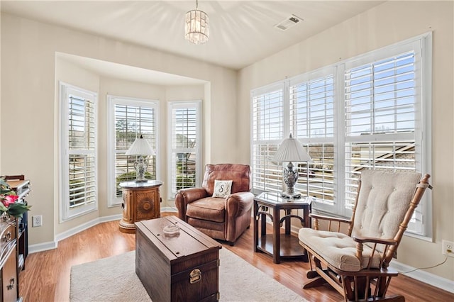 living area with visible vents, baseboards, and wood finished floors