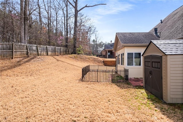 view of yard with an outbuilding, a storage unit, and fence