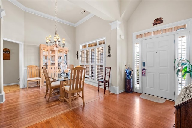 foyer with light wood-style flooring, a high ceiling, and an inviting chandelier