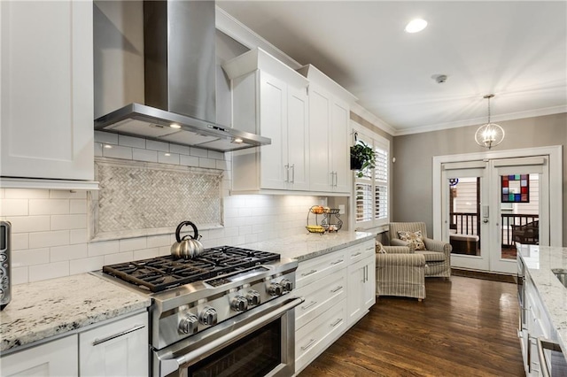kitchen with wall chimney exhaust hood, white cabinets, french doors, light stone counters, and high end range