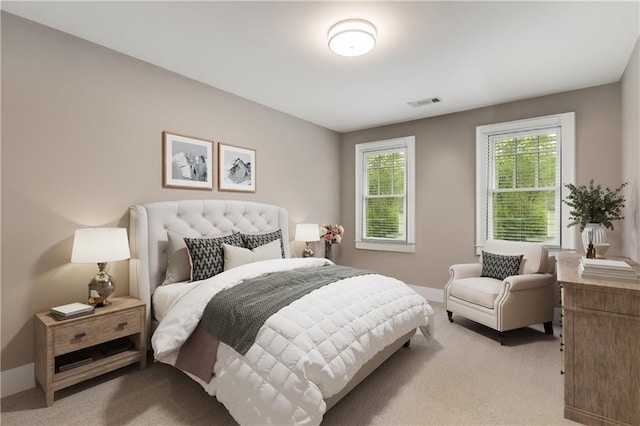 bedroom featuring light carpet, visible vents, and baseboards