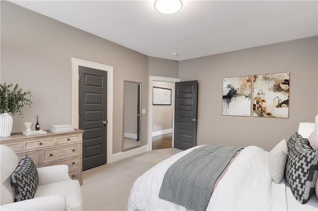 bedroom with baseboards and light colored carpet