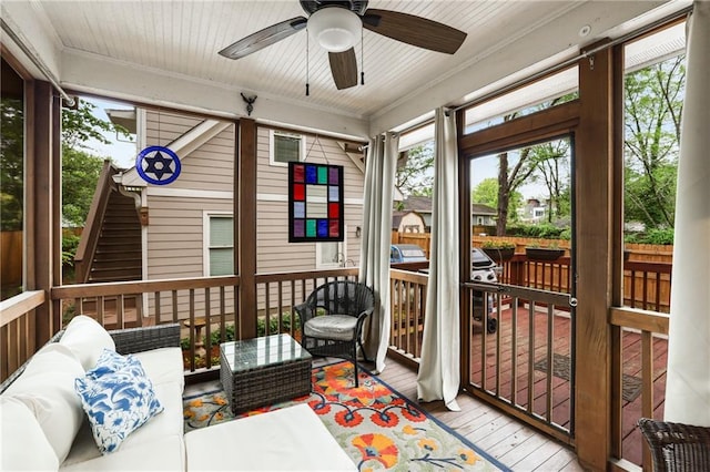 sunroom / solarium with ceiling fan and an outdoor hangout area