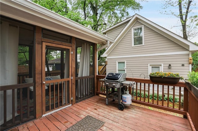 wooden deck with grilling area and a sunroom
