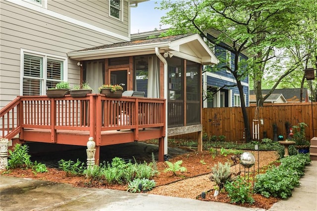 wooden deck with a sunroom and fence