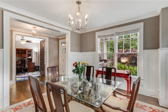 dining space featuring a wainscoted wall, wood finished floors, and a decorative wall
